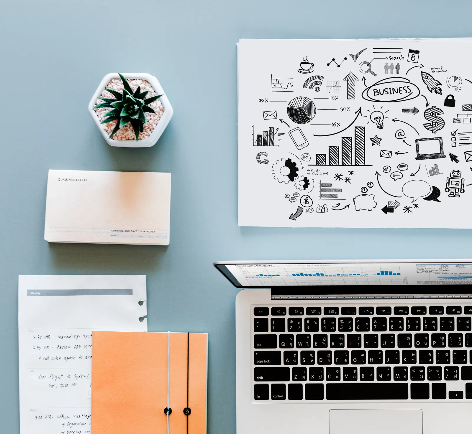 Desk with a laptop, business sketches and printed sales material